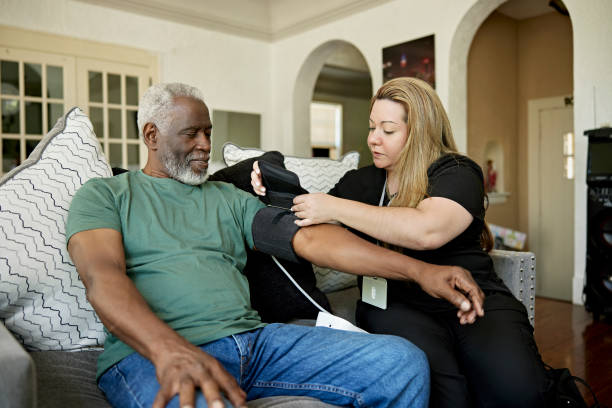 Caregiver fitting a blood pressure cuff for a senior man