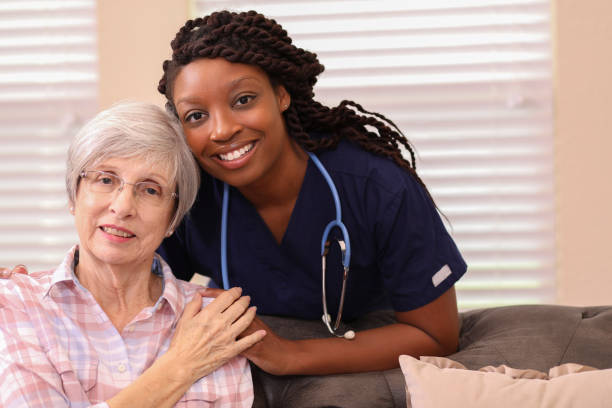 A caregiver warmly embracing a smiling senior client at home